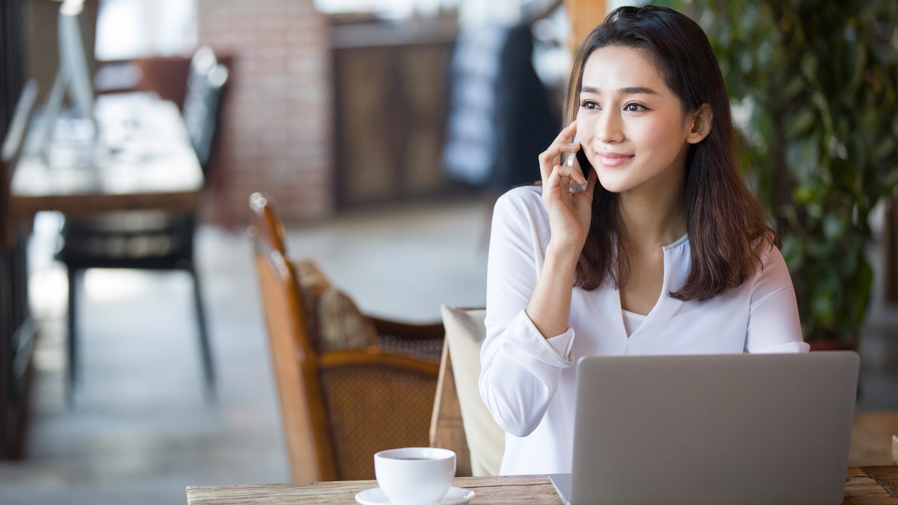 A woman is calling her friend by a phone;image used for HSBC phone banking.