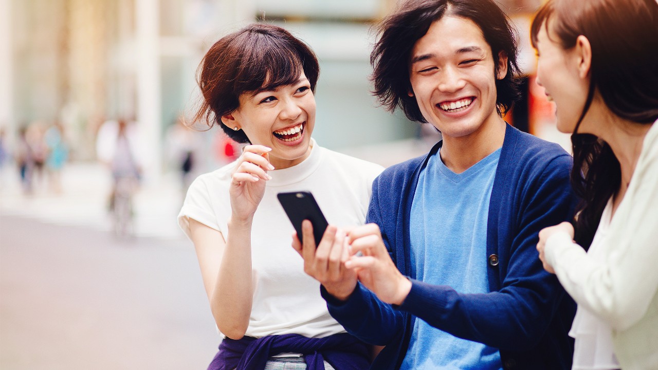 Three people chatting on the street happily; imaged used for HSBC Taiwan FX order page.