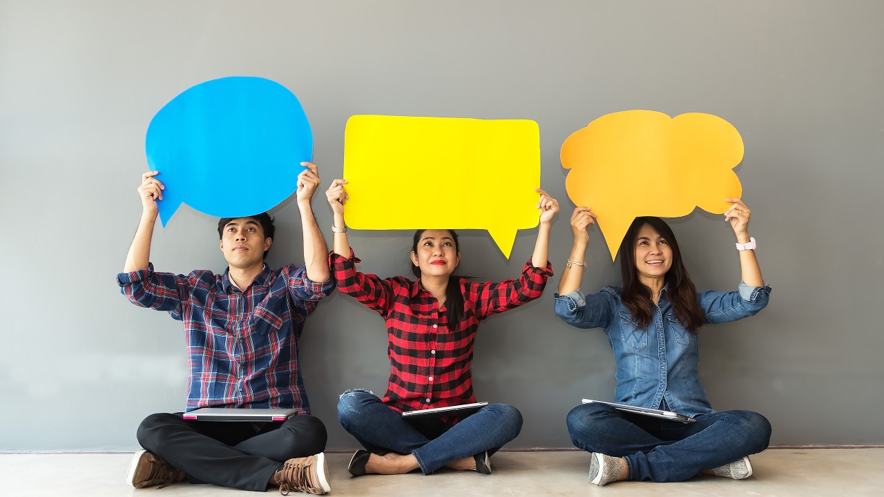 Three people raising empty paper bubble; image used for investment risk tolerance page.