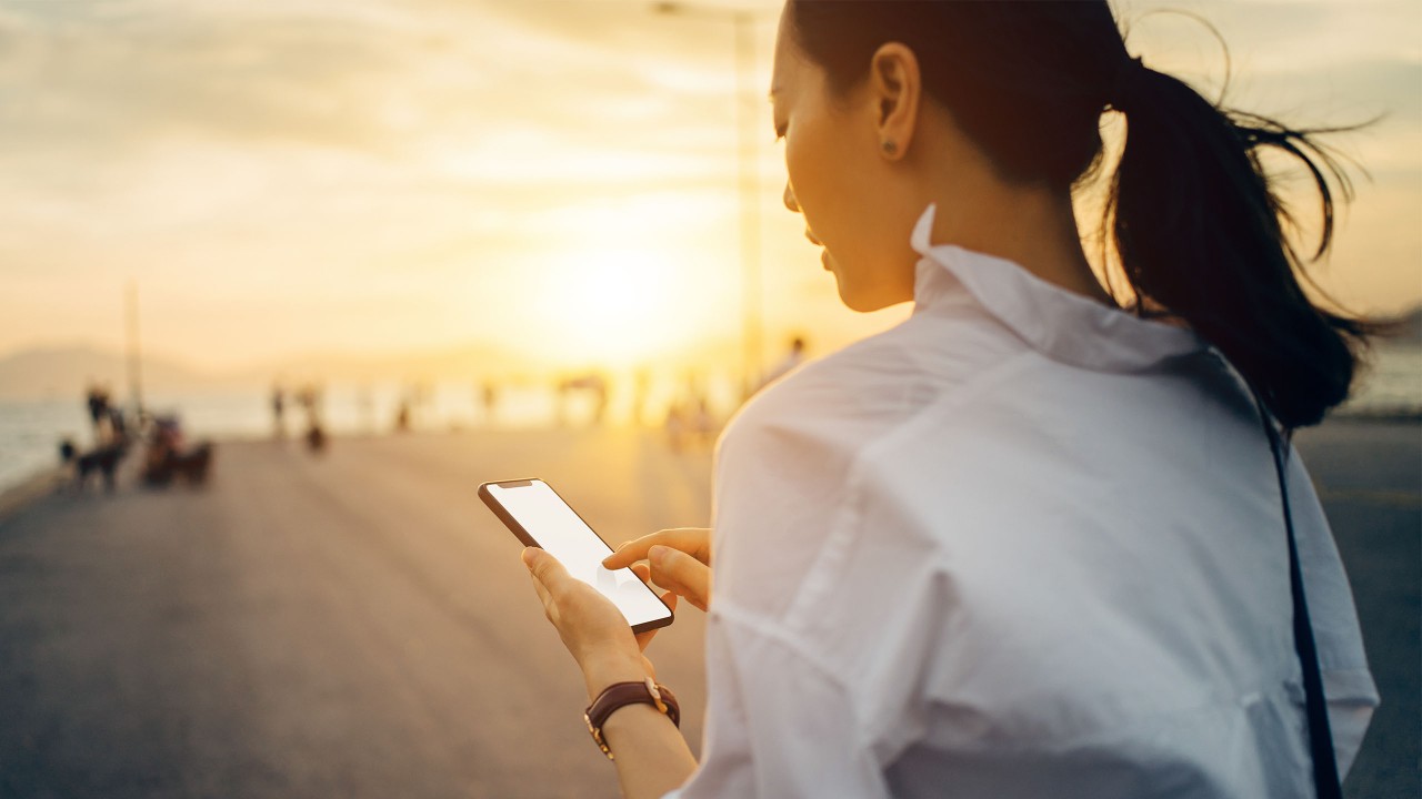 A lady is watching a smartphone; image used for HSBC Online security. 