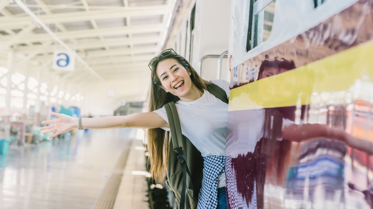 A girl is waving her hand at her seat in a train; image used for HSBC Taiwan roadside assistance page. 