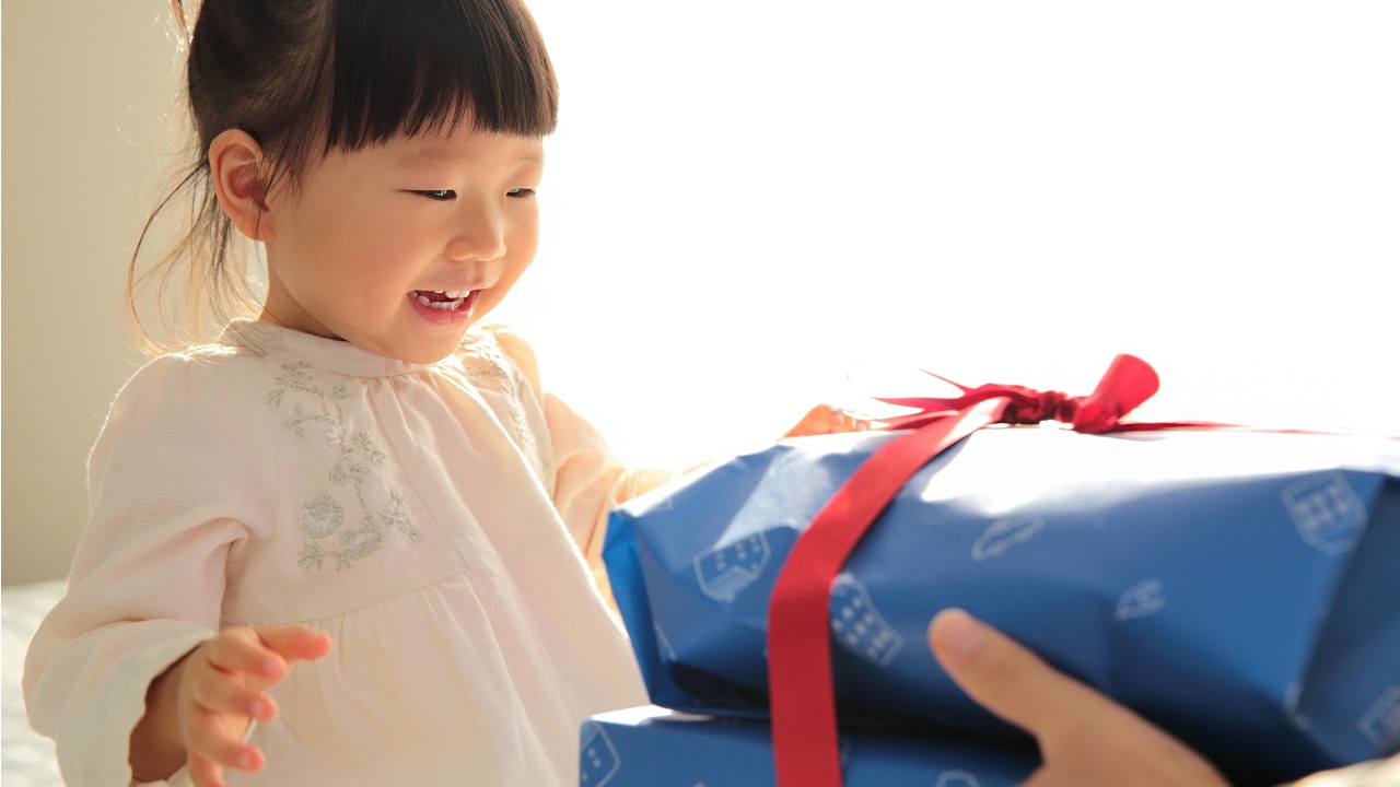 A happy little girl receive her big gift; imaged used for HSBC Taiwan HSBC Cashback Titanium Credit Card page.